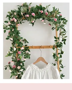 Primer plano de vestido infantil blanco con cuello de volantes y fondo de rosas