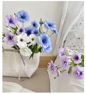 Close-up of artificial poppy flower arrangement in blue and purple tones in a basket
