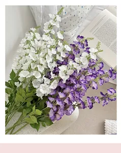 Close-up of white and purple artificial delphinium flowers in a cozy home setting