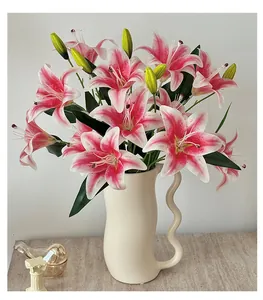 Detailed view of pink and white faux lily flowers in a cream ceramic wave vase