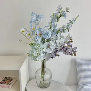 Elegant blue hydrangea and orchid faux flowers in a glass vase for home decor