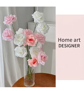 Detailed close-up of realistic pink and white artificial roses in a glass vase