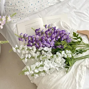 Artificial larkspur flowers in purple and white on a bed for home decor and weddings