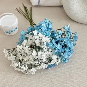 Kunstmatige gipskruidbloemen in blauw en wit in een decoratieve emmer voor in huis