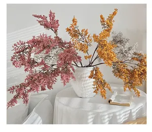 Dettaglio di steli floreali finti colorati in un vaso di ceramica bianca per l'arredamento