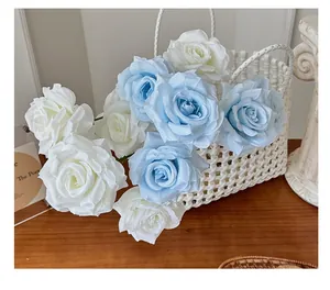 Detail van lichtblauwe en witte zijden rozen met gelaagde bloemblaadjes in een mand