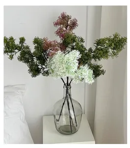 Purple and green faux asparagus ferns in a glass vase for modern home decor