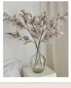Dettaglio di piccoli fiori artificiali bianchi in vaso di vetro per arredo minimal