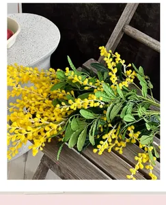 Détail de fleurs de mimosa jaunes posées sur une chaise en bois vintage décorative