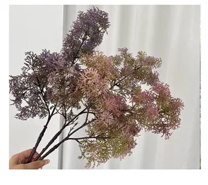 Detail of hand-held purple faux coral fern branches for home floral arrangement decor