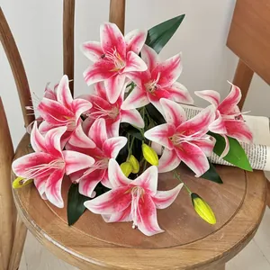 Artificial pink lily bouquet with buds and leaves on a vintage wooden chair