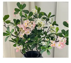 Détail de fleurs artificielles roses et blanches réalistes dans un pot gris mat