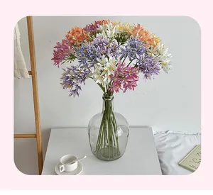 Close-up of artificial Agapanthus silk flowers in glass vase for home table decor