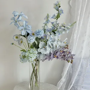 Detailed close-up of blue roses and silk hydrangeas in a transparent glass vase
