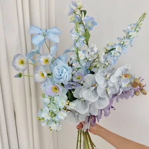 Detail of hand-held artificial bouquet with blue peonies and orchids for home decoration