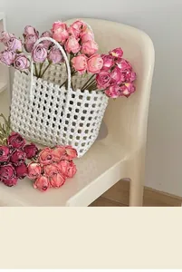 Detail of vintage artificial rose bouquet in white woven basket for home decor