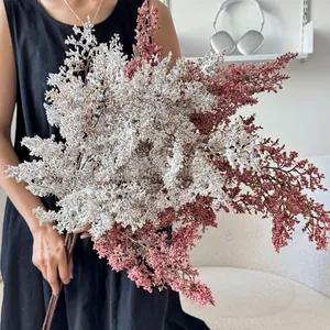 Bouquet di astilbe artificiale bianco e rosa fumo tenuto da modella per arredo