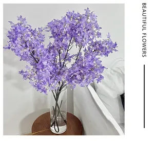 Detailed close-up of lush purple artificial lilac flowers in a glass vase for home decor