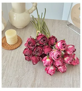 Gros plan d'un bouquet de roses artificielles vintage aux pétales séchés et tiges vertes