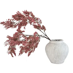 Fiori artificiali rosa in vaso di ceramica bianca per decorazione domestica minimale
