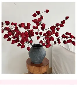 Close-up of red Physalis artificial flowers in a matte grey vase for home decor