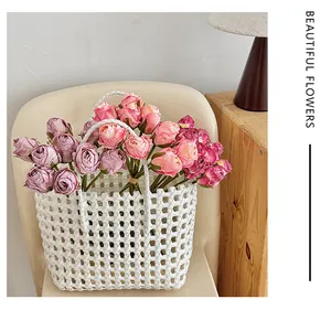 Panier tressé blanc avec roses roses artificielles sur une chaise pour déco chic