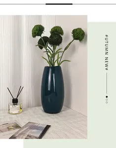 Jarrón de cerámica verde oscuro brillante con follaje natural para decoración moderna