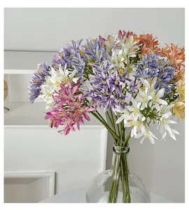 Detailed view of colorful artificial Agapanthus flowers in a glass vase for home decor