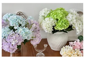 Detailed view of large multi-color artificial hydrangeas in ceramic and metal vases