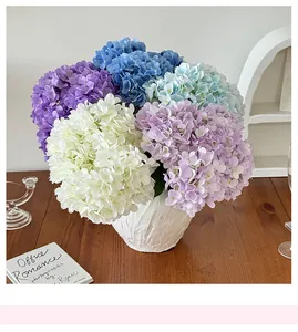Detail of colorful artificial hydrangea bouquet in a white textured ceramic vase on a table