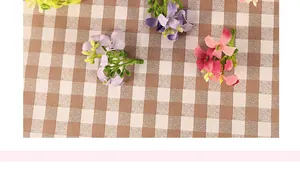 Gros plan de têtes de fleurs d'osmanthus artificielles violettes et roses sur tissu quadrillé
