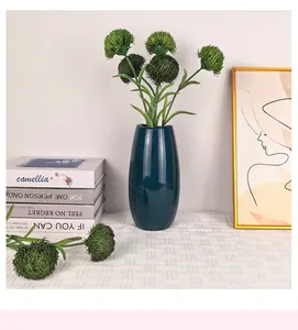 Detalle de flores verdes de clavel en jarrón de cerámica verde azulado moderno