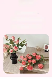 Detailed close-up of pink artificial roses with lifelike leaves in a modern black vase