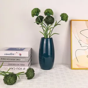 Flor de clavel verde artificial en un jarrón de cerámica azul oscuro para decoración