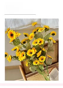 Detailed close-up of artificial sunflowers with yellow silk petals and textured green leaves