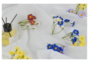 Détail de têtes de marguerites artificielles colorées pour accessoires cheveux DIY