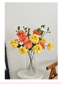 Close-up of yellow and orange peony artificial flowers in a glass vase for home decor
