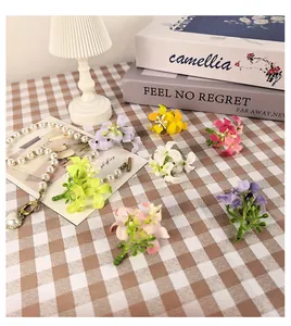 Détail de têtes de fleurs d'osmanthus artificielles colorées et collier de perles fantaisie