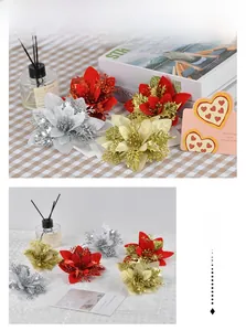 Detail of glittering artificial poinsettia flowers in red, gold, and silver for Christmas decor