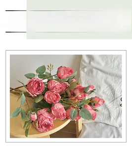 Detail of vintage pink artificial roses with realistic petals and foliage on a wooden stool