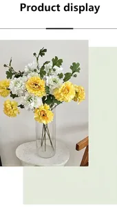 Detailed view of artificial yellow and white peony flowers in a clear glass vase