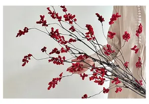 Detail of faux red berry stems with realistic texture and vibrant fruit for home decor