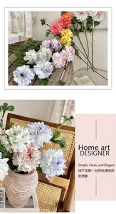 Artistic layout of colorful faux peonies in a vase with Nordic home decor accessories