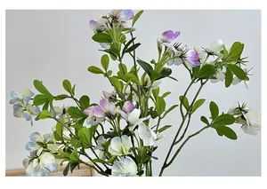 Macro detail of artificial sweet pea flowers with purple, blue, and white petals