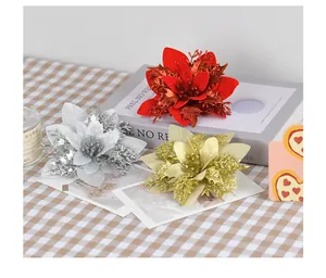 Close-up of glittered artificial poinsettia flowers in red, gold, and silver for decor