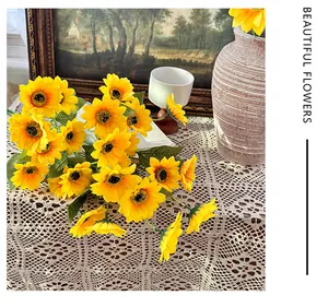 Detailed close-up of vibrant artificial sunflowers on a delicate white lace tablecloth