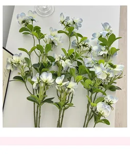 Detailed top view of realistic silk blue pea flowers on a clean white desk surface