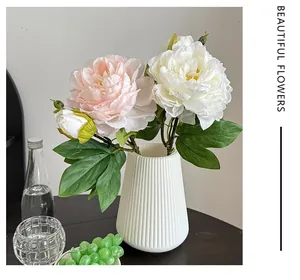 Pivoines artificielles dans un vase en céramique blanche texturé pour décoration