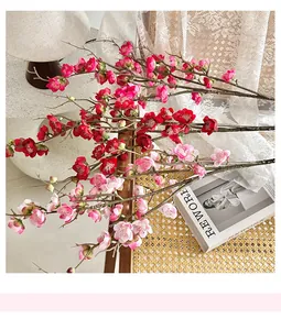 Close-up of lifelike silk plum blossom branches with detailed pink petals on a chair