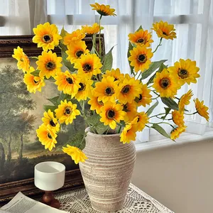 Artificial sunflower bouquet in ceramic vase with realistic petals and green leaves